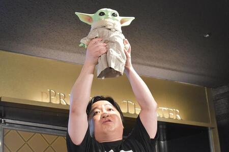 　『スター・ウォーズ／マンダロリアン・アンド・グローグー』イベントで、グローグーを掲げるニッポンの社長・ケツ（５月２１日・大阪市内）