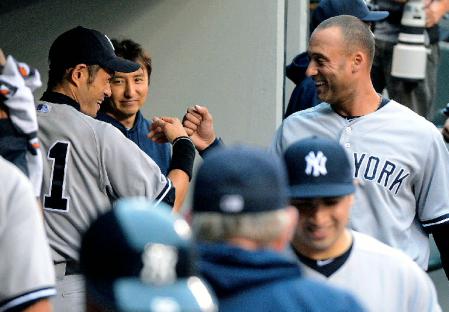 　マリナーズ戦で１回の守備を終え、ベンチでジーター（右）とタッチするヤンキースのイチロー＝セーフコ・フィールド（共同）