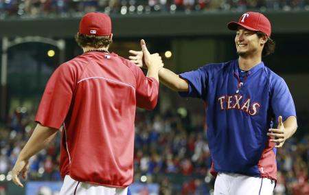 　笑顔でホランド（左）とタッチするレンジャーズのダルビッシュ（共同）