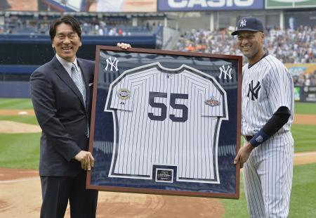 　引退セレモニーで、ヤンキースのジーター（右）から額に納められた記念のユニホームを受け取る松井秀喜氏＝２８日、ヤンキースタジアム（共同）