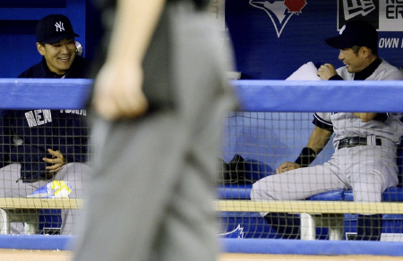 　ブルージェイズ戦の３回、生還したイチロー（右）と笑顔で話すヤンキース・田中将＝トロント（共同）