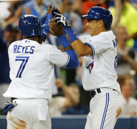 　ヤンキース戦の５回、ラスマスの適時打で生還し、レイエス（左）と喜ぶブルージェイズ・川崎＝トロント（共同）