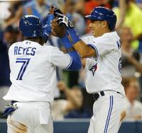 　ヤンキース戦の５回、ラスマスの適時打で生還し、レイエス（左）と喜ぶブルージェイズ・川崎＝トロント（共同）