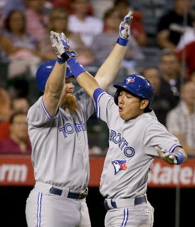 　エンゼルス戦の４回、犠飛で生還し、リンド（左）とハイタッチして喜ぶブルージェイズ・川崎＝アナハイム（ＡＰ＝共同）