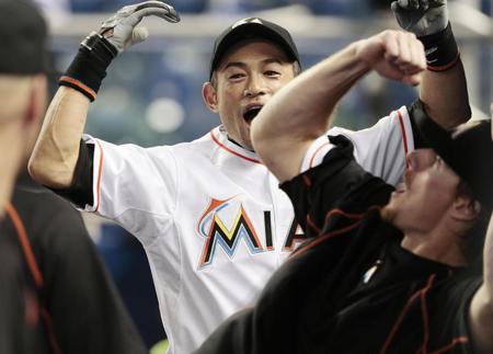 　ロッキーズ戦の前、ベンチでチームメートと気合を入れるマーリンズのイチロー（共同）