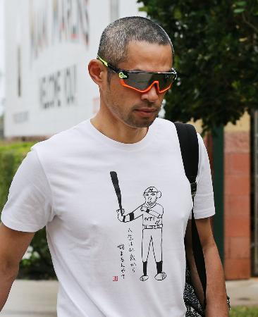 　「人生は４２歳から始まるんやて」と書かれたＴシャツを着てキャンプインするマーリンズのイチロー＝ジュピター（共同）