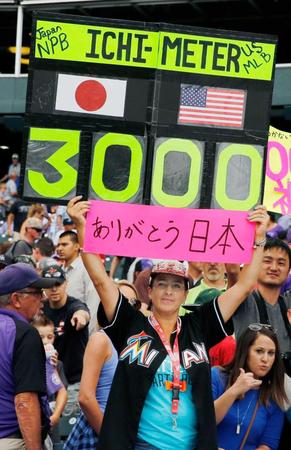 　「イチ・メーター」と「ありがとう日本」と書かれたボードを掲げるエイミー・フランツさん（共同）