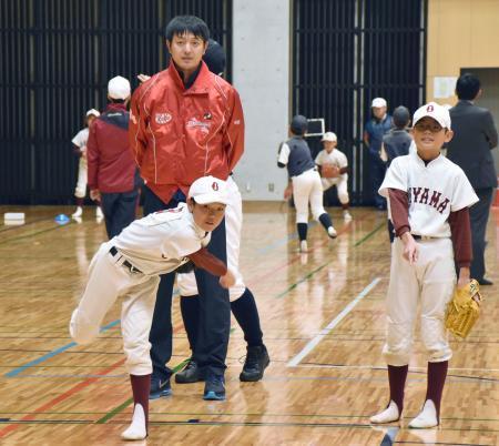 　子どもたちに投球の指導をする岩隈久志投手＝４日午後、熊本市