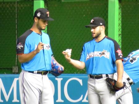 　球宴でダルビッシュ（左）にカーブの握りを教えるマクラーズ（７月１１日撮影）