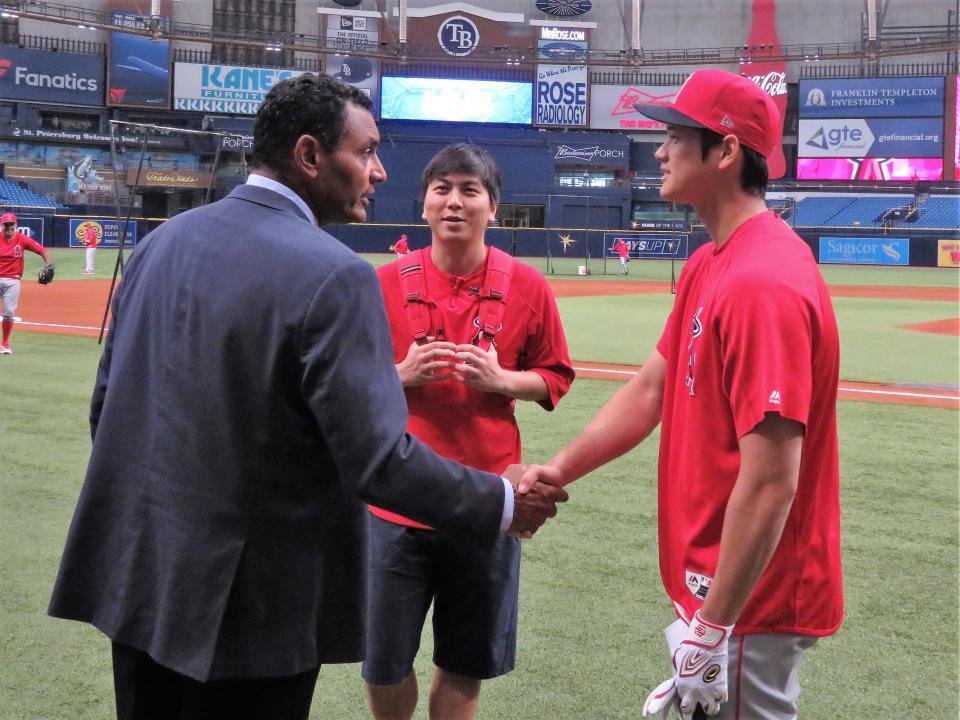 元西武のデストラーデ氏（左）と握手を交わし、笑顔を見せる大谷（撮影・小林信行）