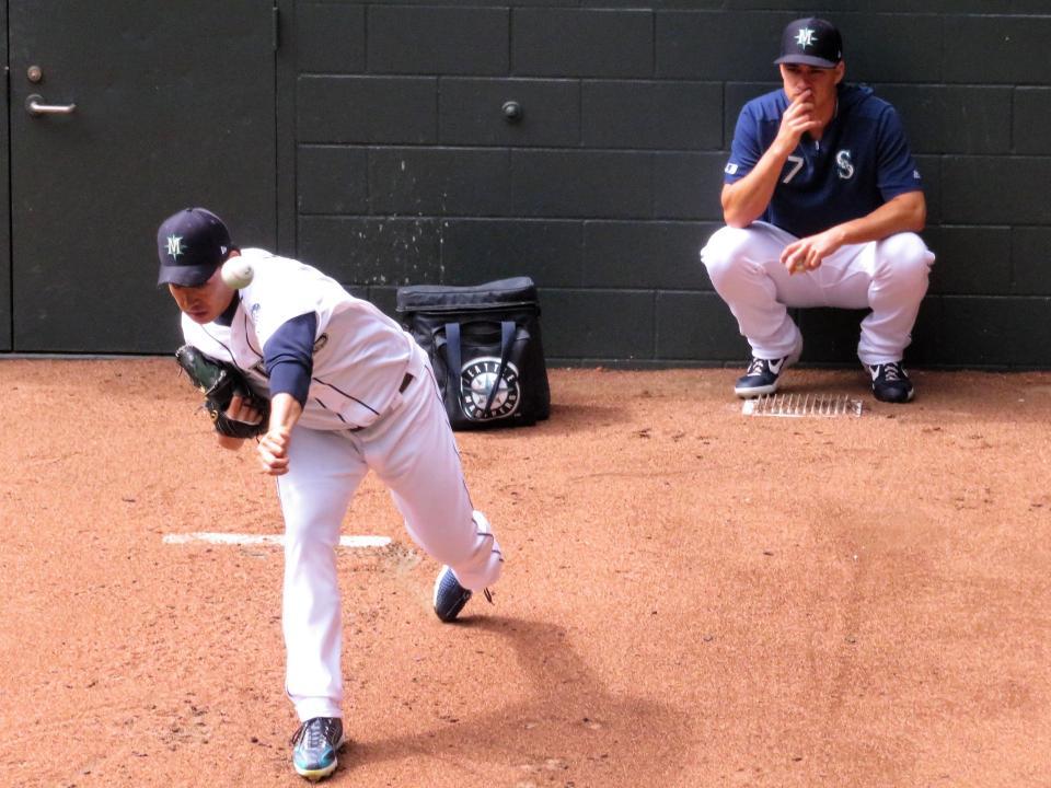 　同僚のゴンザレス（右）が見守る中、投球練習をする菊地（撮影・小林信行）