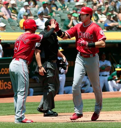 アスレチックス戦の１回、プエロの適時打で生還し、三走ラステラ（左）に迎えられるエンゼルス二走の大谷＝オークランド（共同）