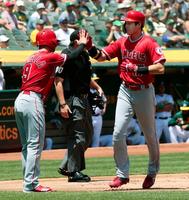 アスレチックス戦の１回、プエロの適時打で生還し、三走ラステラ（左）に迎えられるエンゼルス二走の大谷＝オークランド（共同）