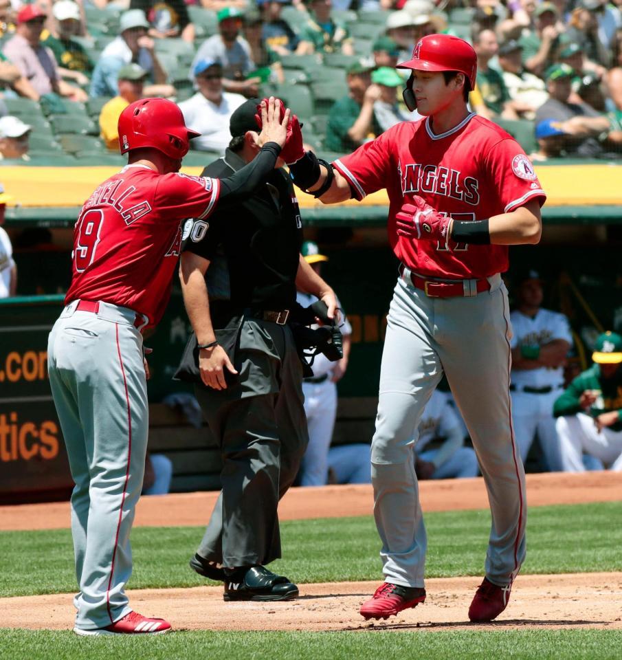 アスレチックス戦の１回、プエロの適時打で生還し、三走ラステラ（左）に迎えられるエンゼルス二走の大谷＝オークランド（共同）