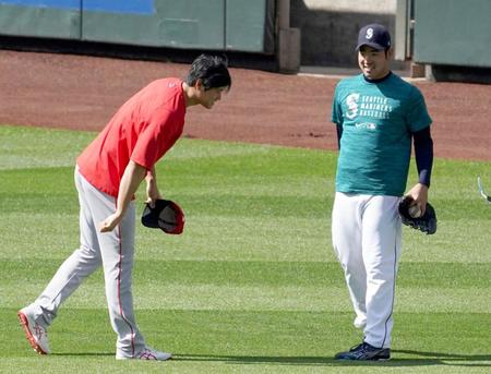 試合前の練習の合間に、マリナーズ・菊池（右）にあいさつするエンゼルス・大谷＝シアトル（共同）