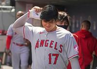 マリナーズ戦で１回の攻撃を終え、ベンチで右肘付近を気にするそぶりを見せるエンゼルス・大谷＝シアトル（共同）