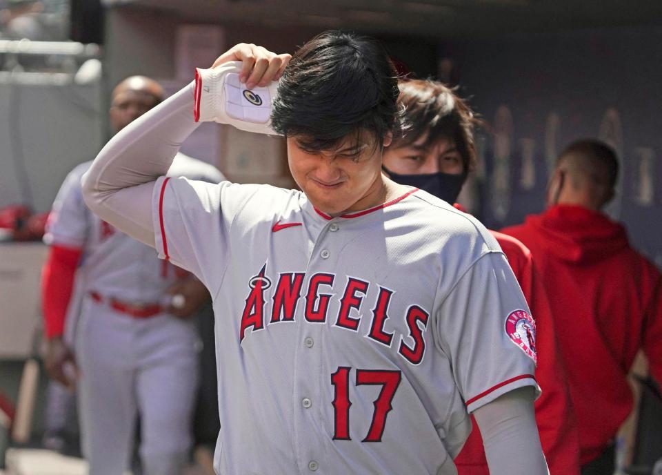 マリナーズ戦で１回の攻撃を終え、ベンチで右肘付近を気にするそぶりを見せるエンゼルス・大谷＝シアトル（共同）