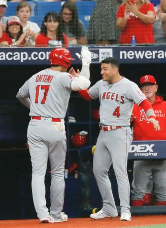 レイズ戦の１回、先頭打者本塁打を放ち、ベンチ前でＪ・イグレシアス（右）に迎えられるエンゼルス・大谷＝セントピーターズバーグ（共同）