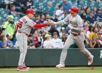 　マリナーズ戦の３回、33号本塁打を放ち三塁コーチとタッチを交わすエンゼルス・大谷＝シアトル（共同）