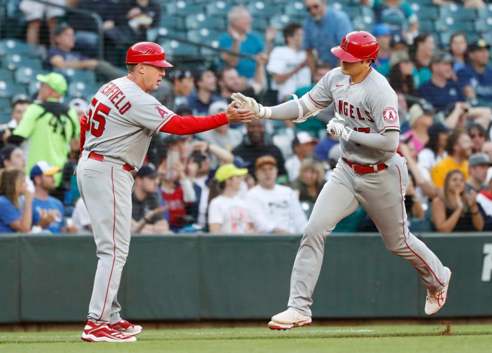 　マリナーズ戦の３回、33号本塁打を放ち三塁コーチとタッチを交わすエンゼルス・大谷＝シアトル（共同）