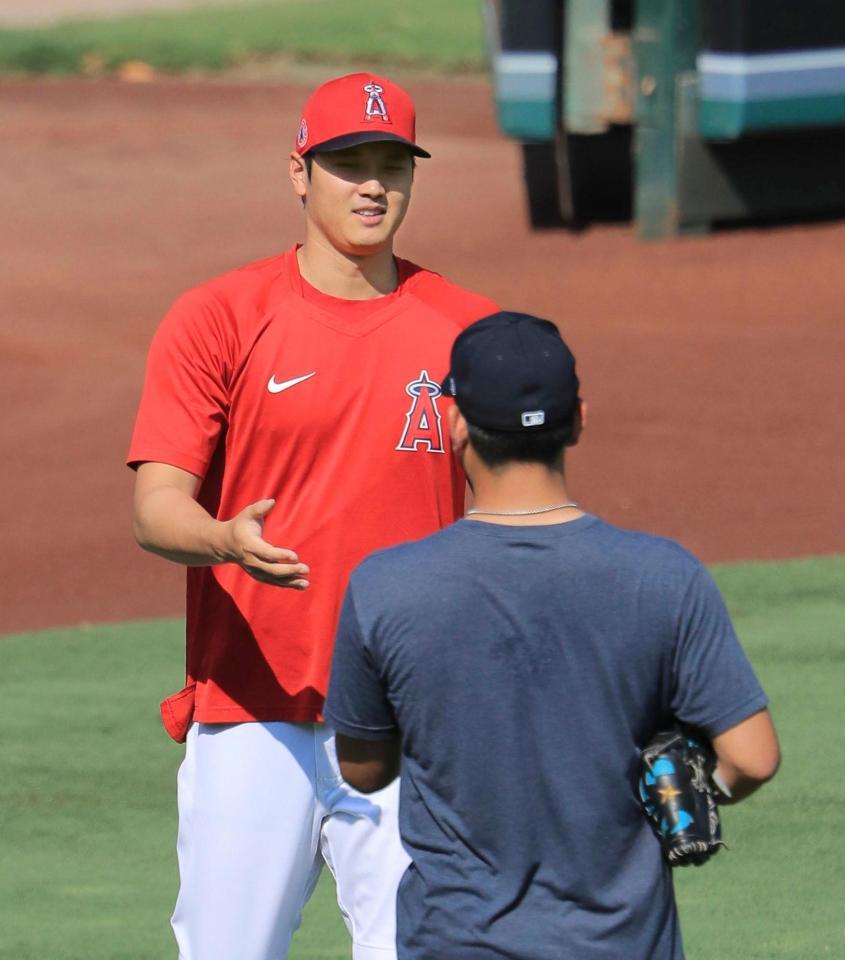 試合前の練習中、マリナーズ・菊池（手前）とあいさつを交わすエンゼルス・大谷＝アナハイム（共同）