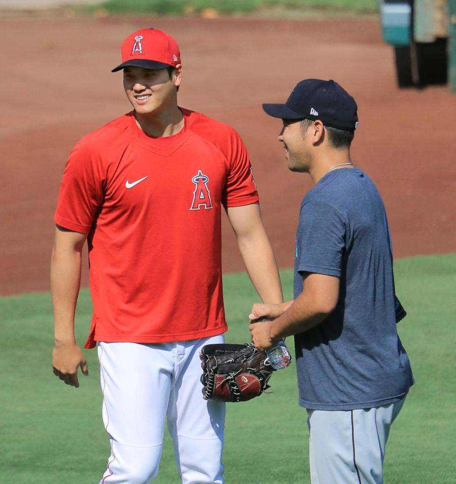 試合前の練習中、マリナーズ・菊池（右）とあいさつを交わすエンゼルス・大谷＝アナハイム（共同）