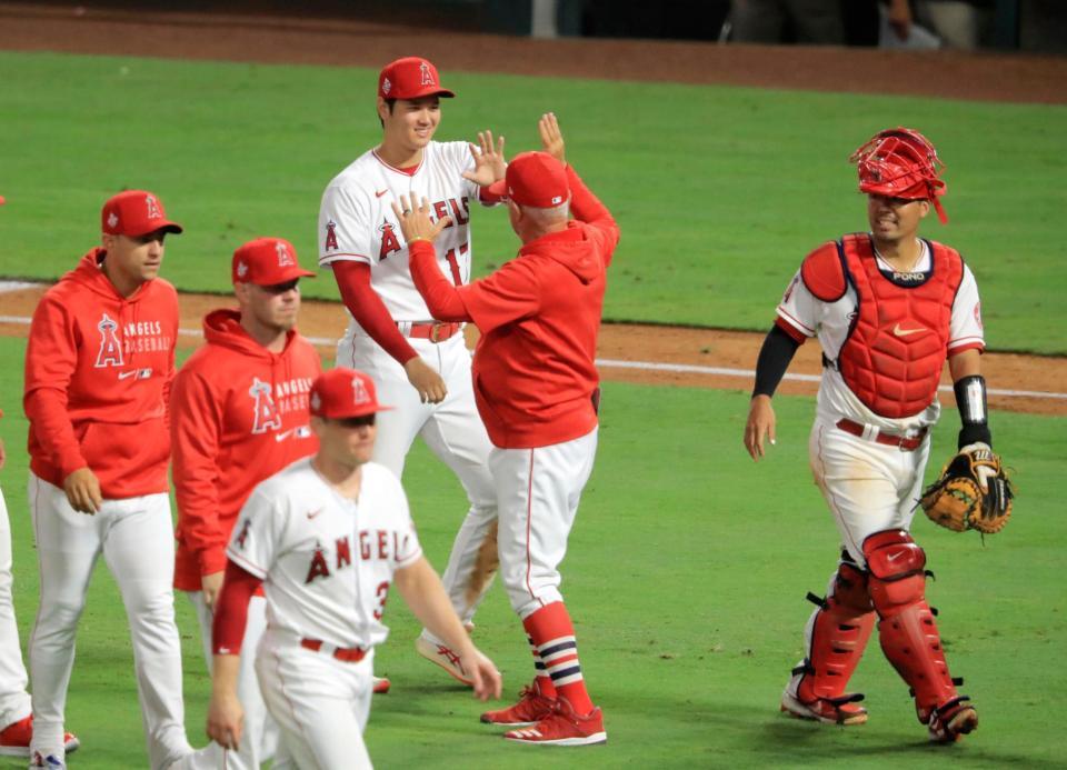 パドレスに勝利し、マドン監督（右から２人目）とタッチを交わし喜ぶエンゼルス・大谷＝アナハイム（共同）