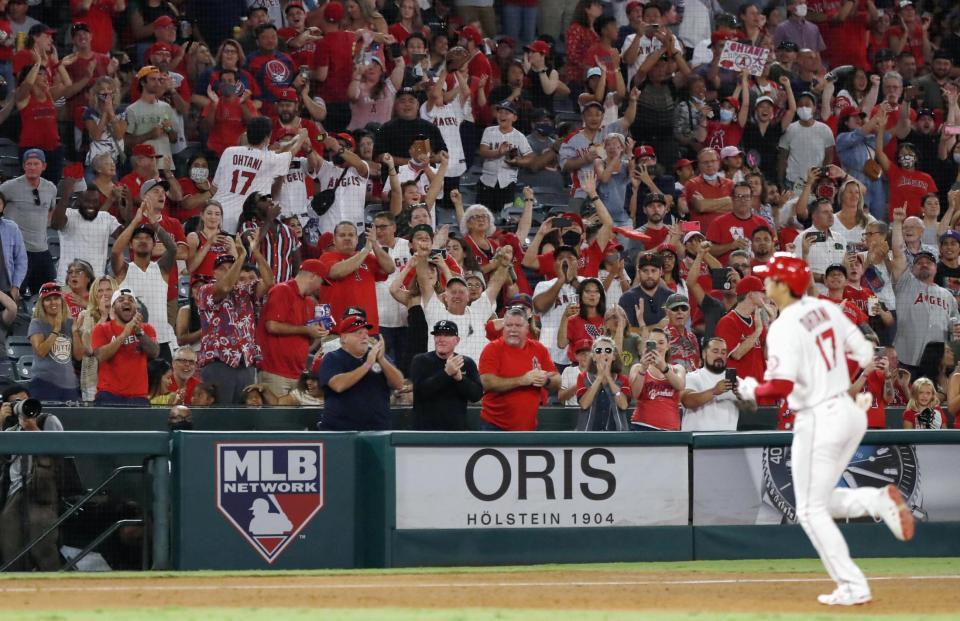 　６回、エンゼルス・大谷（右）が43号３ランを放ち、スタンドで喜ぶファン＝アナハイム（共同）