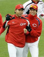 　ウオーミングアップで今村猛と笑顔でランニングする前田健太＝２０１２年３月