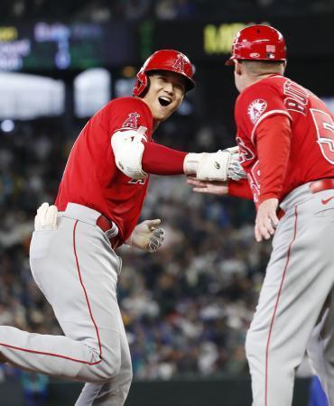　マリナーズ戦で４６号本塁打を放ち、三塁コーチとタッチを交わす米大リーグ、エンゼルスの大谷翔平＝３日、シアトル（共同）