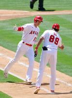 ブルージェイズ戦の３回、２打席連続となる11号２ランを放ち一塁コーチとタッチを交わすエンゼルス・大谷＝アナハイム（共同）