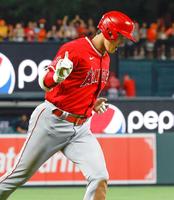 　人さし指を立てながら塁を回る大谷（共同）