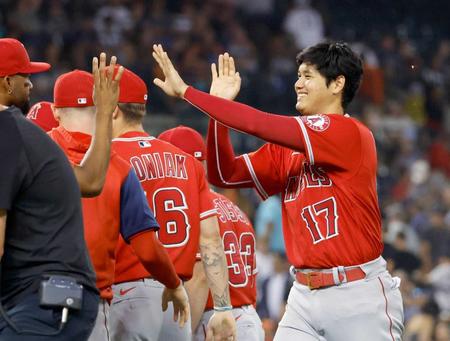 　タイガースに勝利し、ナインとタッチを交わす大谷（右端）＝共同