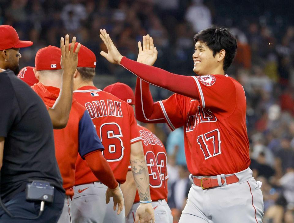 　タイガースに勝利し、ナインとタッチを交わす大谷（右端）＝共同