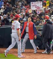 開幕戦の８回を終え、ベンチに戻るチームメートを迎える大谷（中央）＝共同