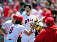 　本塁打を放った大谷にかぶとを渡すフィリップス（８）＝４月９日、共同