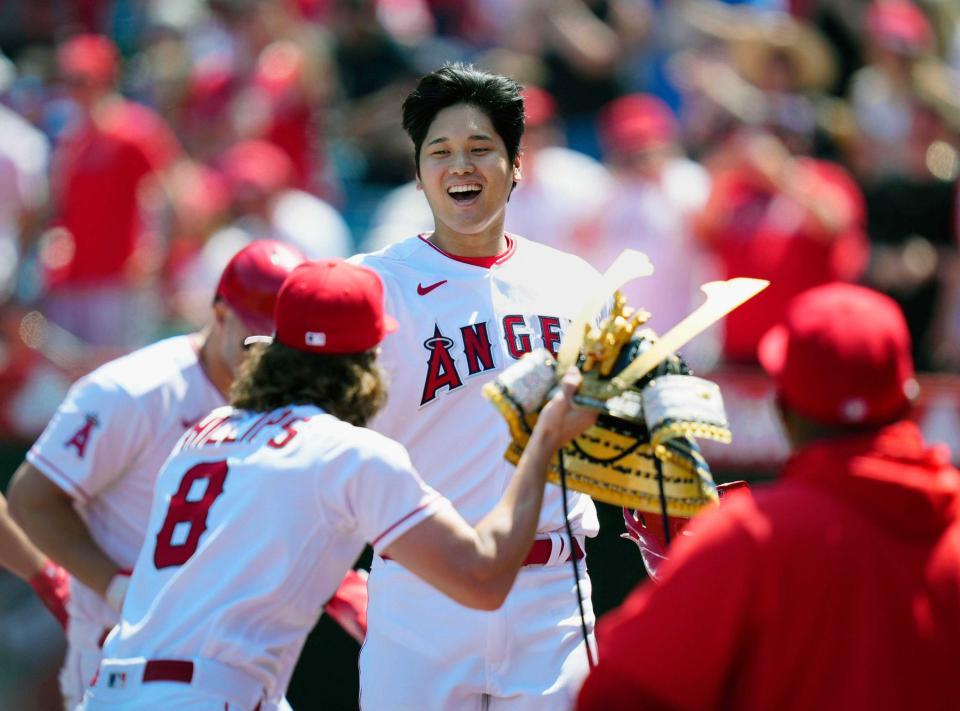 　本塁打を放った大谷にかぶとを渡すフィリップス（８）＝４月９日、共同