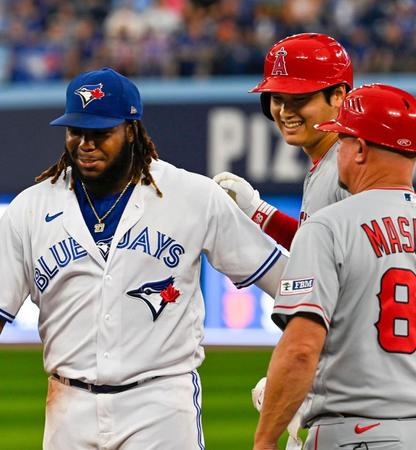 　６回、左前打を放ち、一塁手ゲレーロ（左）と談笑する大谷