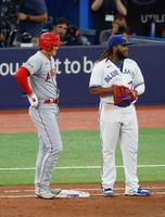　６回、左前打で出塁し、一塁手ゲレーロ（右）と談笑する大谷