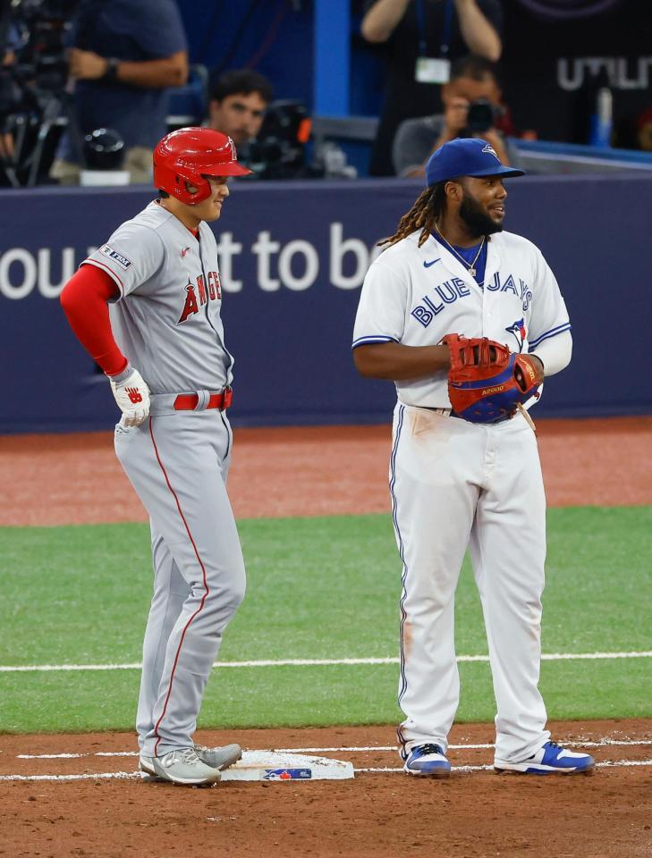 　６回、左前打で出塁し、一塁手ゲレーロ（右）と談笑する大谷