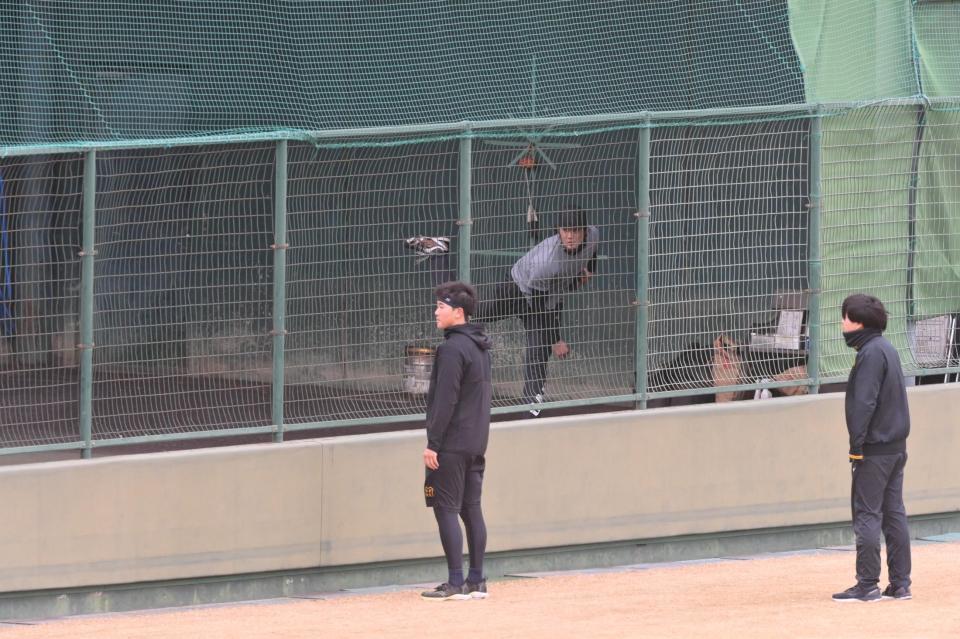 　ブルペンで投球する藤浪。手前は門別（撮影・立川洋一郎）