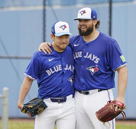 　練習の合間にチームメートと肩を組む菊池（左）＝共同