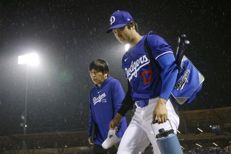 　雨の中引き揚げる大谷（手前）と水原通訳（提供・共同通信社）