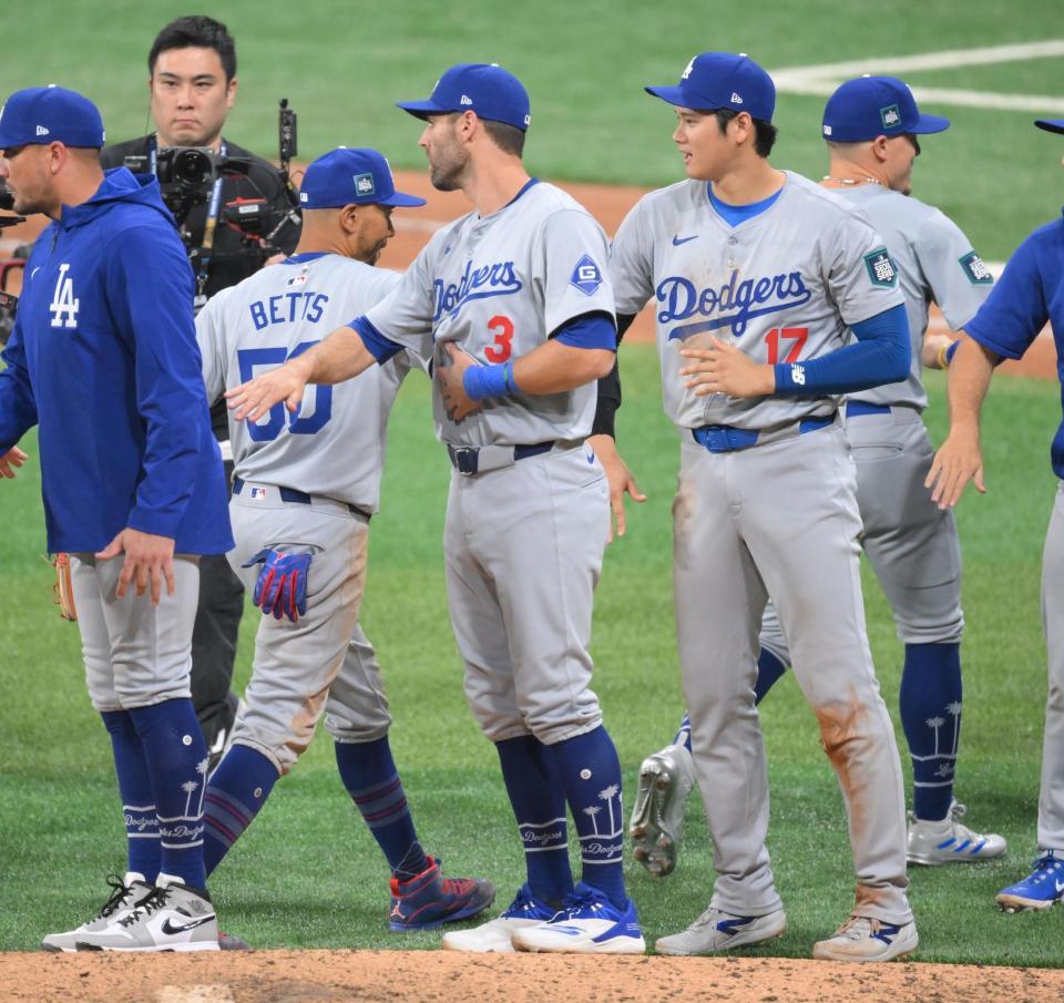 　自身のダメ押し打で韓国での開幕戦を勝利し、ナインと喜びを分かち合う大谷（撮影・伊藤笙子）