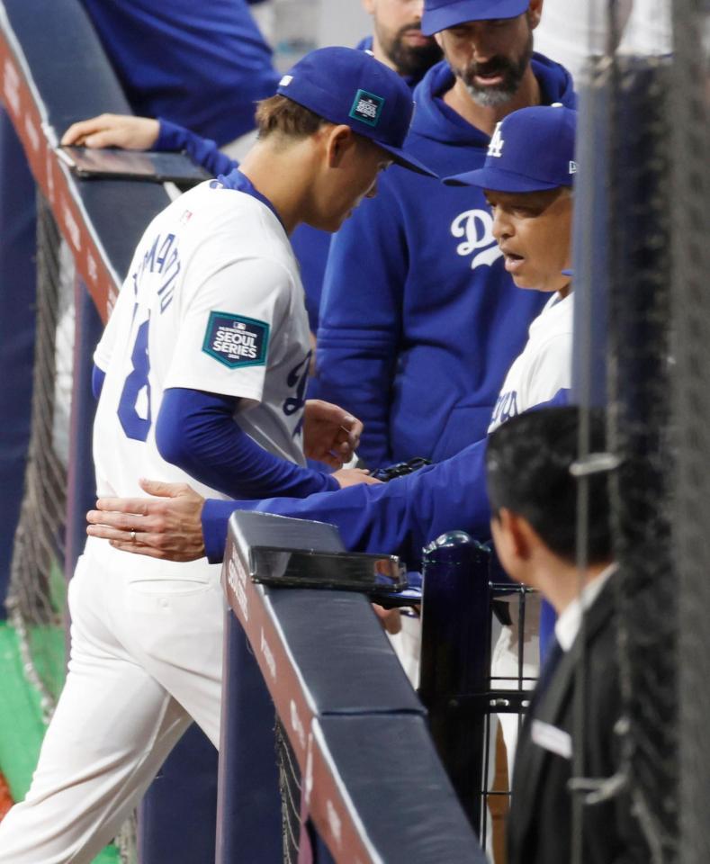 　１回を投げ終えベンチに戻る山本（左）と迎えるロバーツ監督