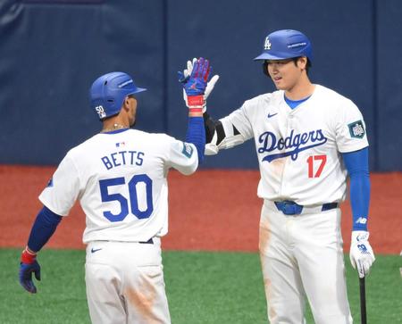 　今季ＭＬＢ１号を放ったムーキー・ベッツ（左）とハイタッチを交わす大谷翔平＝３月２１日、韓国