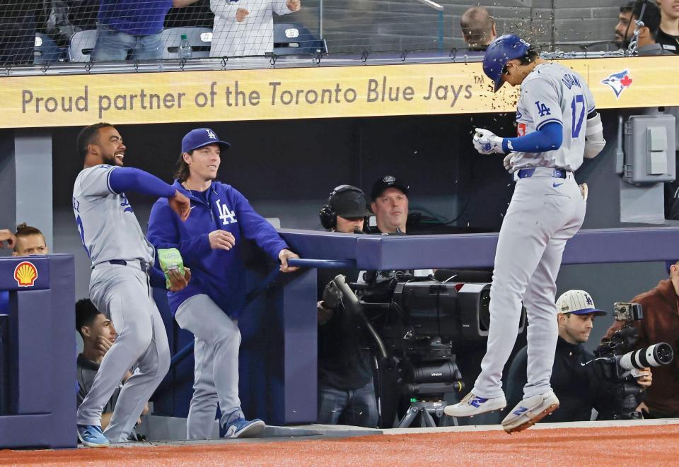 　１回、先制の７号ソロを放ち、ヒマワリの種を浴びる大谷（右）＝共同