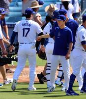 　ロイヤルズに勝利し、タッチを交わす大谷（左）と山本（共同）