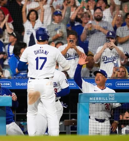 　エンゼルス戦の５回、先制の22号２ランを放ちロバーツ監督に迎えられる大谷（共同）