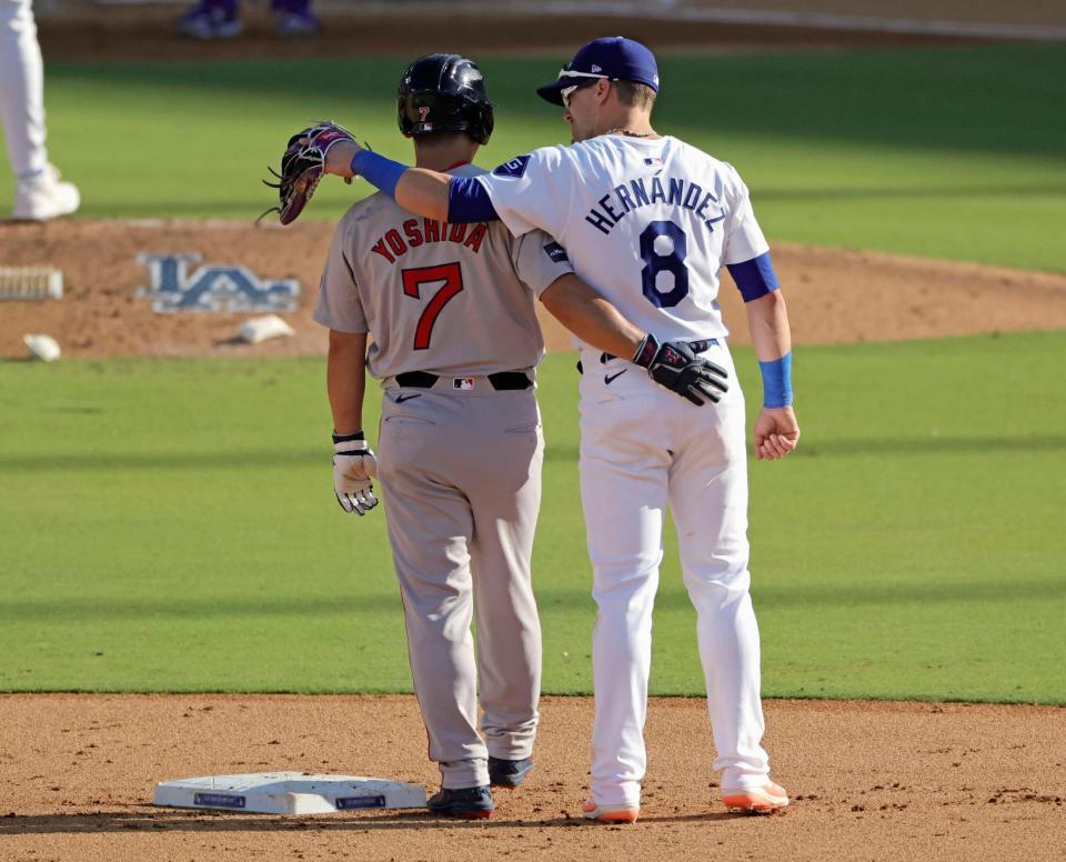 　ドジャース戦の６回、後続の安打で二進し、Ｅ・ヘルナンデス（右）とあいさつを交わす吉田